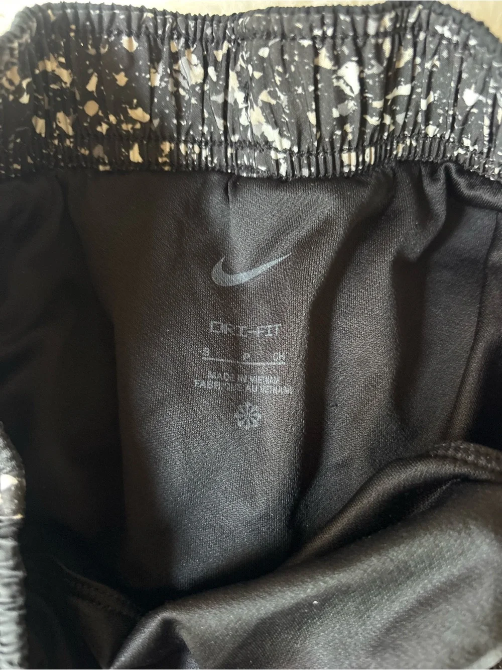 Nike Black Athletic Shorts with White Swoosh and Speckled Trim